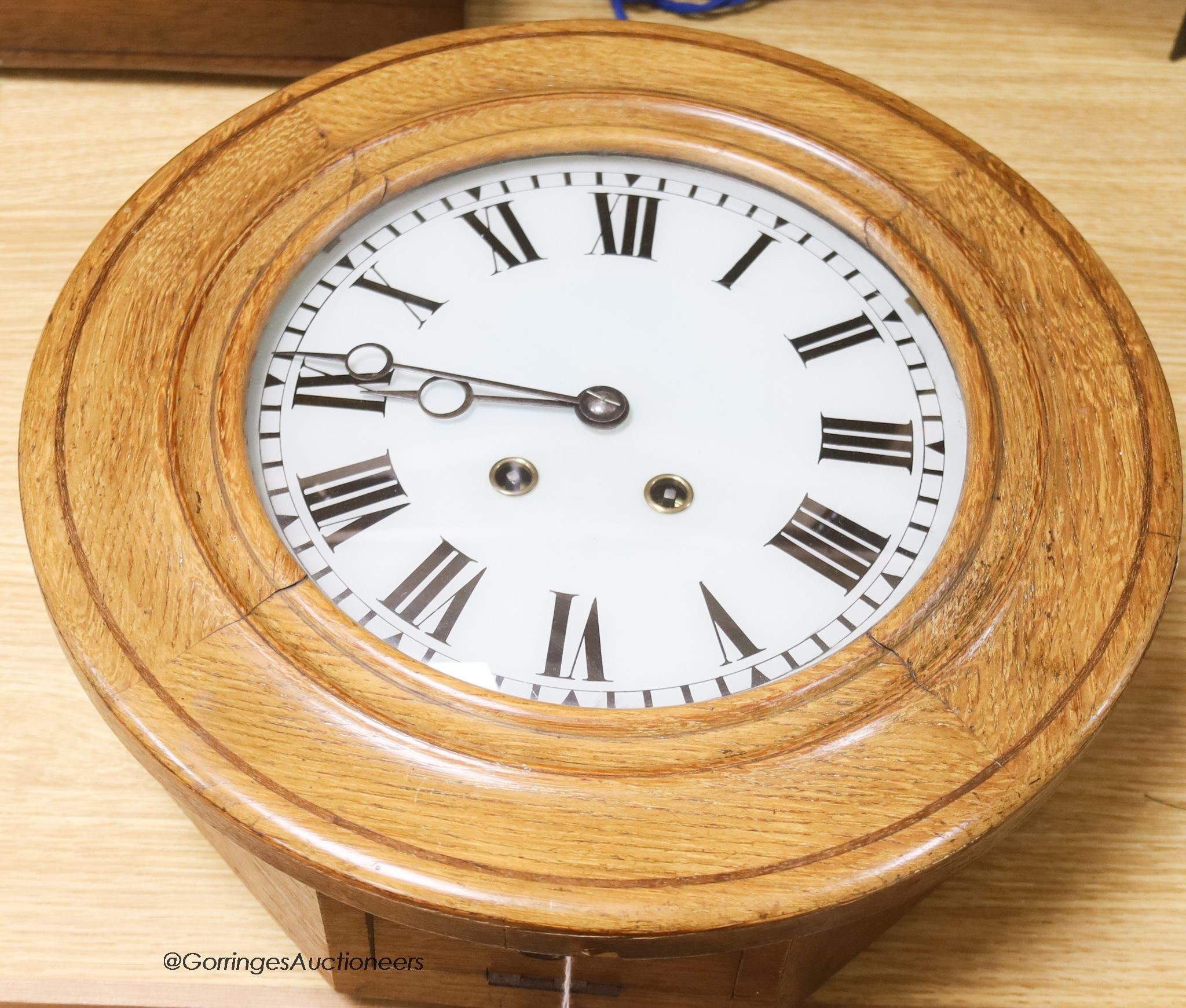 An Edwardian pale oak wall clock, with key and pendulum, diameter 38cm